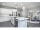 Bright, modern kitchen features a spacious island, stainless steel appliances, and a dining area at 373 Fosterton Cottage Way, Raleigh, NC 27603