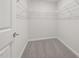 Empty walk-in closet features metal shelving, gray carpeting, and white door at 4006 Kidd Pl, Durham, NC 27703