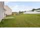 A spacious, grassy backyard features a concrete patio and a wood fence, offering privacy at 4038 Patriot Ridge Ct, Raleigh, NC 27610
