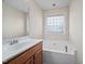 Close up of bathroom showing a soaking tub, vanity, and large mirror with lighting at 4038 Patriot Ridge Ct, Raleigh, NC 27610
