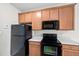 View of kitchen, showcasing refrigerator, oven, microwave, and wooden cabinets at 4038 Patriot Ridge Ct, Raleigh, NC 27610