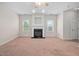 This living room features a fireplace, windows for natural light, and carpet flooring at 4038 Patriot Ridge Ct, Raleigh, NC 27610