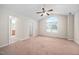 Large carpeted main bedroom with a ceiling fan and window with an arched transom at 4038 Patriot Ridge Ct, Raleigh, NC 27610