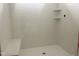 All-white tiled shower with a built-in bench and shelves, offering a clean aesthetic at 47 Tee Time Ter, Benson, NC 27504