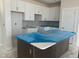 Kitchen under construction features gray subway tile and white cabinets with an island wrapped in blue plastic at 50 Rainfall Dr, Pittsboro, NC 27312
