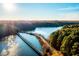 Stunning aerial view showcasing a picturesque lake surrounded by vibrant fall foliage, bridge, and tree-lined roads at 5057 Lundy Dr # 101, Raleigh, NC 27606