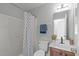 Bright bathroom features a shower with blue and white patterned shower curtain, modern vanity, and updated fixtures at 5210 Blue Lagoon Ln, Raleigh, NC 27610