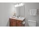 Bathroom with cherry wood vanity, white countertop and large mirror at 5210 Blue Lagoon Ln, Raleigh, NC 27610