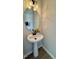 Updated powder room features pedestal sink, modern light fixture and wood-look flooring at 5210 Blue Lagoon Ln, Raleigh, NC 27610