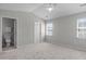 Neutral bedroom features vaulted ceiling, two windows for natural light and carpeted floor at 5210 Blue Lagoon Ln, Raleigh, NC 27610