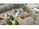 An aerial view showcases the property, adjacent road, and treeline bordering the residence at 603 W Main St, Haw River, NC 27258