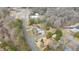 Aerial view highlighting this house in a wooded neighborhood with a long road and buildings nearby at 603 W Main St, Haw River, NC 27258