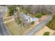 An aerial view displays a well-maintained home with a long driveway and mature trees in a rural setting at 603 W Main St, Haw River, NC 27258