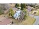 An aerial view of a well-kept home with a metal roof, mature trees, and a neatly manicured lawn at 603 W Main St, Haw River, NC 27258