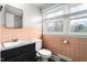 Retro bathroom features pink tiles, toilet, vanity, and window at 603 W Main St, Haw River, NC 27258