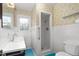 Quaint bathroom featuring white tiled walls, a shower, and a blue floor, giving a clean, vintage look at 603 W Main St, Haw River, NC 27258