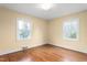 Well-lit bedroom with hardwood floors and two large windows, providing a bright and inviting space at 603 W Main St, Haw River, NC 27258