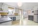 Open kitchen with white cabinets, a stainless steel fridge, and sight lines into a connected dining area at 603 W Main St, Haw River, NC 27258