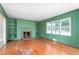 Light-filled living room with a fireplace, built-in shelves, hardwood floors, and windows at 603 W Main St, Haw River, NC 27258