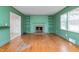 Bright living room featuring a brick fireplace, built-in shelves, hardwood floors, and large windows at 603 W Main St, Haw River, NC 27258