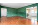 A view of the living room with hardwood floors, green walls, and an open doorway to the dining area at 603 W Main St, Haw River, NC 27258