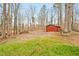 The backyard features a storage shed, lush green grass, mature trees and large cleared area at 605 Canterbury Rd, Sanford, NC 27330