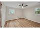 This neutral bedroom has two windows providing natural light, updated light fixture and light wood floors at 605 Canterbury Rd, Sanford, NC 27330