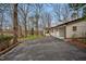 Spacious driveway leading to a well-maintained home, surrounded by lush trees, offering privacy and charm at 605 Canterbury Rd, Sanford, NC 27330