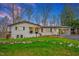 Charming home featuring a black roof, white exterior, manicured lawn, and inviting curb appeal at 605 Canterbury Rd, Sanford, NC 27330