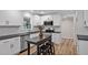Updated kitchen features white cabinets, black countertops, stainless steel appliances, and a wooden kitchen island at 605 Canterbury Rd, Sanford, NC 27330