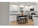 Modern kitchen with white cabinetry, black countertops, and a small island with stools at 605 Canterbury Rd, Sanford, NC 27330