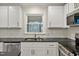 Bright kitchen with white cabinets, granite countertops, stainless appliances, and a view to the screened back porch at 605 Canterbury Rd, Sanford, NC 27330