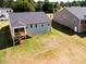 Aerial view of a gray two-story home with a screened porch, a deck, a large yard, and a dark gray roof at 63 Tee Time Ter, Benson, NC 27504