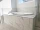 Close up on the soaking tub with marble surround and modern fixtures, offering a spa-like experience at 63 Tee Time Ter, Benson, NC 27504