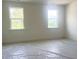 Bright, unfinished bedroom featuring two windows with views of the surrounding landscape at 63 Tee Time Ter, Benson, NC 27504