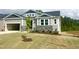 Beautiful craftsman-style home featuring a two-car garage, stone accents, and a freshly planted tree at 63 Tee Time Ter, Benson, NC 27504
