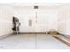 An empty garage with light gray concrete floors, white drywall, and wooden steps leading to the exit door at 63 Tee Time Ter, Benson, NC 27504