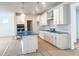 Modern kitchen with white cabinetry, a center island with blue wrap, stainless steel appliances, and stylish pendant lighting at 63 Tee Time Ter, Benson, NC 27504