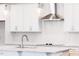 Bright kitchen features white cabinets, a large island, modern fixtures, and stainless steel vent hood at 63 Tee Time Ter, Benson, NC 27504