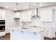Bright kitchen features a large island, stainless vent hood, white cabinets, and tile backsplash at 63 Tee Time Ter, Benson, NC 27504
