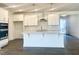 Bright, open kitchen featuring white cabinetry, a large island, modern appliances, and stylish pendant lighting at 63 Tee Time Ter, Benson, NC 27504