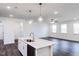 Open concept living room and kitchen with hardwood floors, pendant lighting, and ample space at 63 Tee Time Ter, Benson, NC 27504