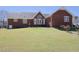 Exterior shot of a brick home with a large backyard, patio and landscaping at 703 E Stanley St, Four Oaks, NC 27524