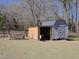 View of backyard shed and covered area with lawnmower storage, plus a swing at 703 E Stanley St, Four Oaks, NC 27524