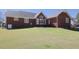 Expansive backyard showcasing a brick home with well-manicured lawn and patio at 703 E Stanley St, Four Oaks, NC 27524