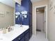 Bathroom featuring blue cabinets, white countertops, and coastal-themed decorations at 703 E Stanley St, Four Oaks, NC 27524