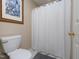 Bathroom featuring a toilet, shower with curtain, and white tiled floors at 703 E Stanley St, Four Oaks, NC 27524