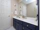 Bathroom featuring coastal-themed decorations, blue cabinets, and a large mirror at 703 E Stanley St, Four Oaks, NC 27524