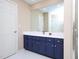 Bathroom featuring blue cabinets, white countertops, and a large mirror at 703 E Stanley St, Four Oaks, NC 27524