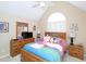Bedroom with a vaulted ceiling, arched window and wooden furniture at 703 E Stanley St, Four Oaks, NC 27524